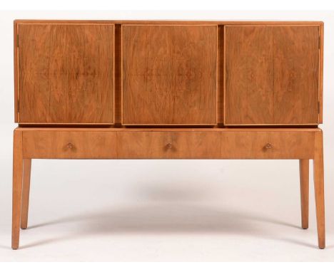 Manner of Alfred Cox/Gordon Russell of Broadway: a mid 20th Century walnut sideboard, the rectangular top above three cupboar