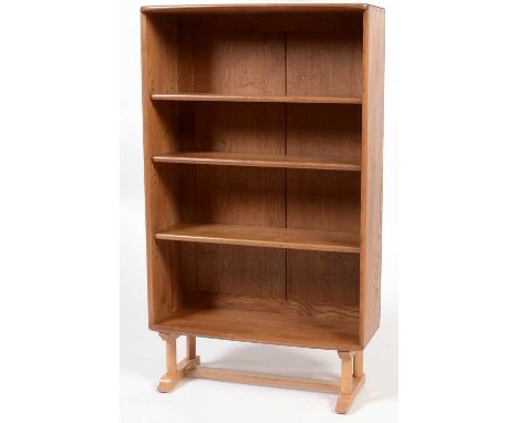 Ercol: a beech and elm open bookcase, with three adjustable shelves, convex fronted, shaped octagonal beech supports with sle