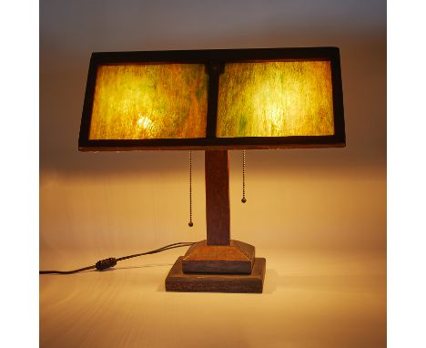 After Stickley, United States. Arts &amp; Crafts Prairie School style table lamp. Wooden base with caramel and green slag gla