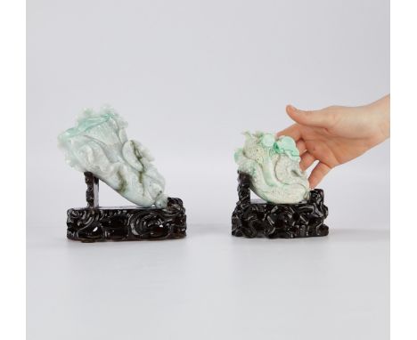 Group of two Chinese jade carvings in the form of cabbages, carved from mottled green and white jade. Both rest on lacquered 