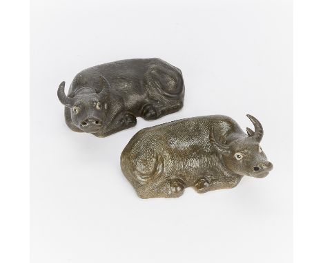 Pair of antique Chinese ceramic water buffalo sculptures. Each buffalo is a mirror of the other; they are depicted laying dow