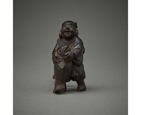 Japanese netsuke carved in the form of a figure carrying a large fish. Possibly of ebonized walnut. With a mark carved along 