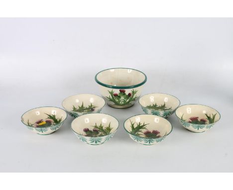 Wemyss pottery thistle decorated bowl 19cm diameter and six finger bowls 14cm diameter, impressed marks to base, (faults) 