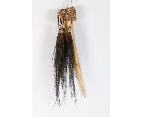 Indonesian Asmat tribal ancestor cassowary-bone dagger the top covered with a woven figure cover with pendant strands of feat