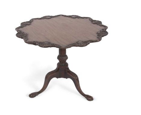 A Georgian mahogany pedestal supper table, the top with a carved shell moulded border raised on a fluted column with tripod b