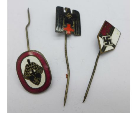 A German Red Cross membership lapel pin, a R.A.B. commemorative enamel lapel pin and a WWII German lapel badge