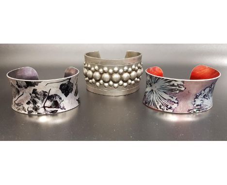 THREE DESIGNER/FASHION BANGLEScomprising a Modernist 1970s Norwegian pewter bangle by Erling Christophersen, with bubble deco