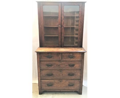 OAK BOOKCASE ON CHESTwith a plain top above a pair of glazed doors opening to reveal adjustable shelves, the base with a moul