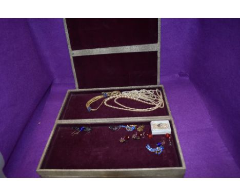 A large vintage jewellery travel case of concertina form containing a small selection of costume jewellery