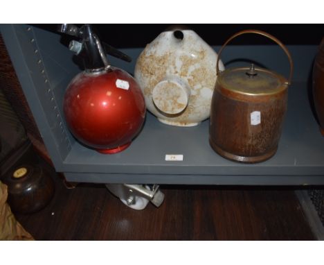 A mid century cocktail mixer soda syphon, an oak cased biscuit barrel and a ceramic foot warmer