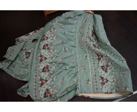 A mint green vintage padded bed throw having rose and floral pattern.