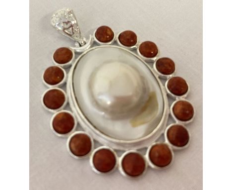 A large oval shaped coral and pearl pendant with pierced work bale. Marked 925. Approx. 6cm x 4.5cm.