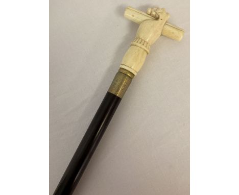 A bone topped walking cane with screw in finial in the form of a hand grasping a scroll.  Approx. 89cm tall.