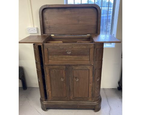 A vintage dark wood top opening bar cabinet. Side cupboards with shelving, corner cupboards with glass holders and 2 door fro