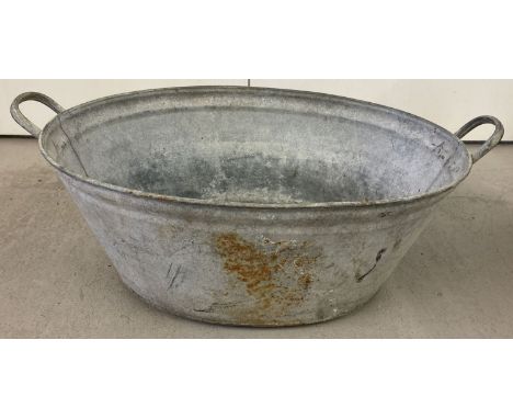 A vintage galvanised oval shaped, 2 handled bath.  Approx. 75cm long.