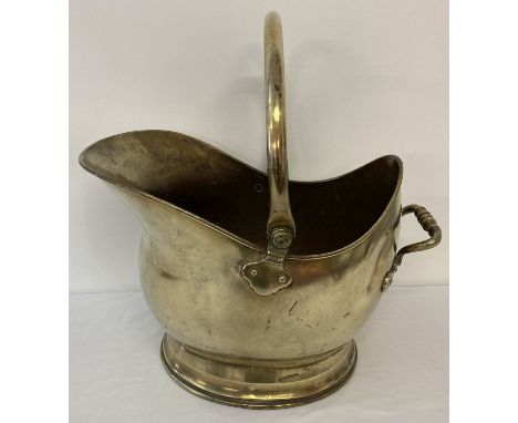 A vintage brass coal scuttle bucket with swing handle and riveted decorative tipping handle.  