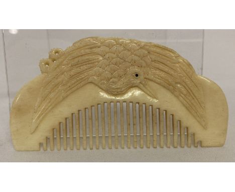 A carved bone comb with bird detail to handle.  Approx. 4.5cm x 8.5cm.
