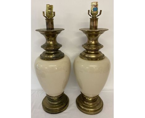 A large pair of heavy brass and cream porcelain lamp bases, with Stiffel stickers to fitments. Need re-wiring. Approx. 59cm t