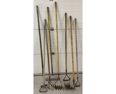 A collection of 8 vintage long handled garden tools. To include rakes, hoes and a lawn aerator. 