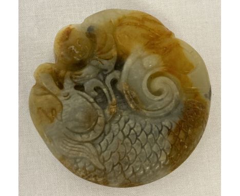 A Chinese Jade roundel depicting a figure riding a dragon. Carved detail to both side.  Approx. 5cm diameter.