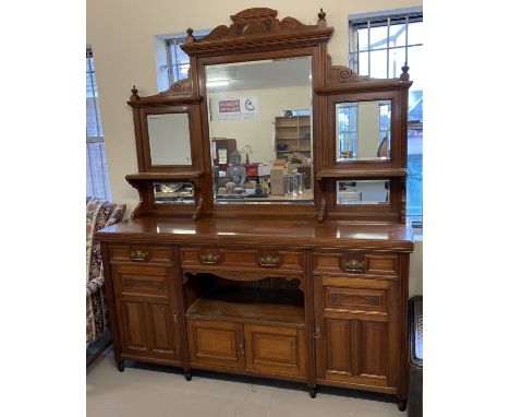 A large Victorian mirror backed side board with carved detail, turned finials &amp; bevel edged glass. 4 cupboards, 3 drawers