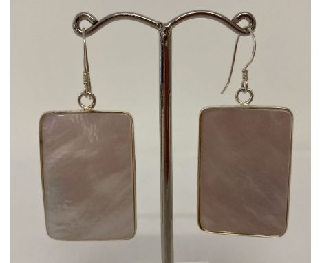 A pair of rectangular shaped silver mounted mother of pearl drop earrings. Marked 925 to reverse. Approx. 3cm x 2.25cm.