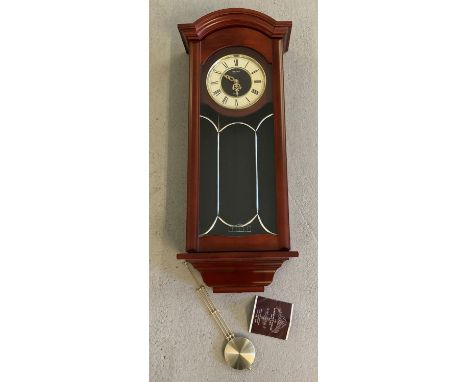A modern Seiko, mahogany cased wall hanging quartz pendulum clock. Complete with pendulum and original instructions. Case app