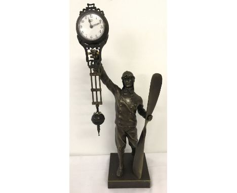 A bronze based figural, swinging pendulum mystery clock. In the from of a Pilot holding a propeller. Total height approx. 38c
