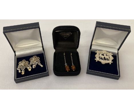 3 boxed items of jewellery. A pair of white metal filigree design drop earrings. Together with a pair of amber chip drop earr