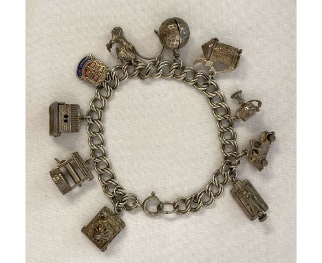 A vintage white metal charm bracelet with 11 silver and white metal charms. 5 charms open to reveal internal parts. Charms in