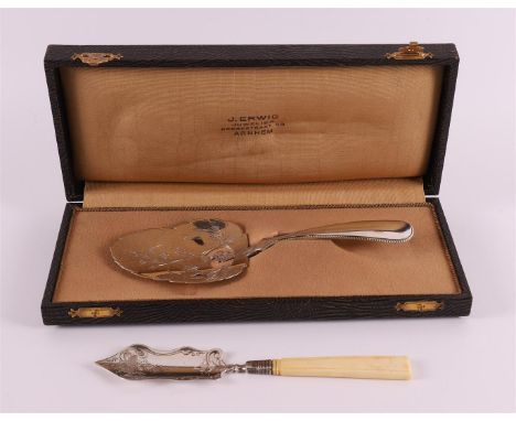 A second grade 835/1000 silver petit four shovel, year letter 1906. Leaf-shaped with chiseled floral decor, handle with pearl