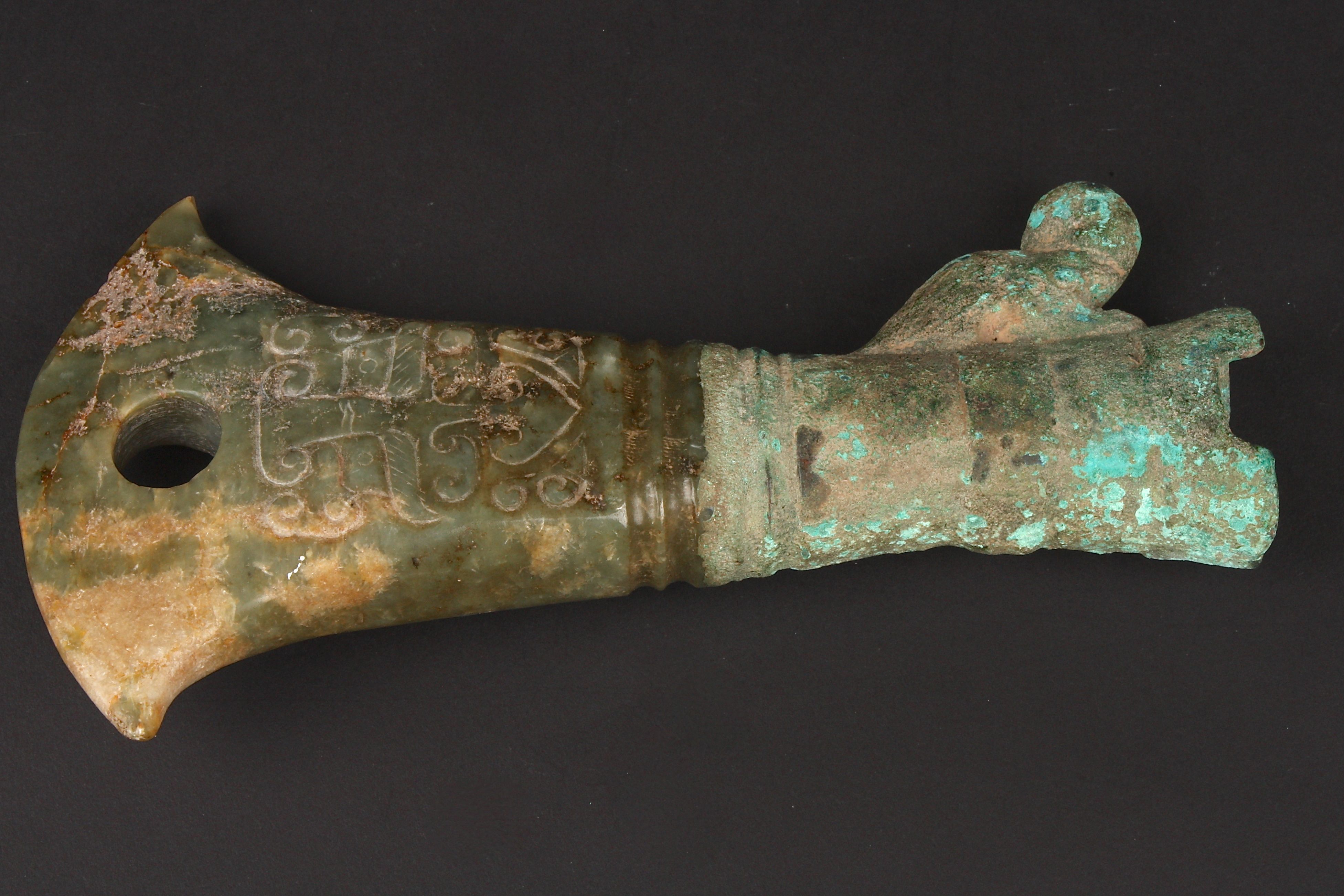 A carved jade axe head in archaic style the jade carved in low relief ...