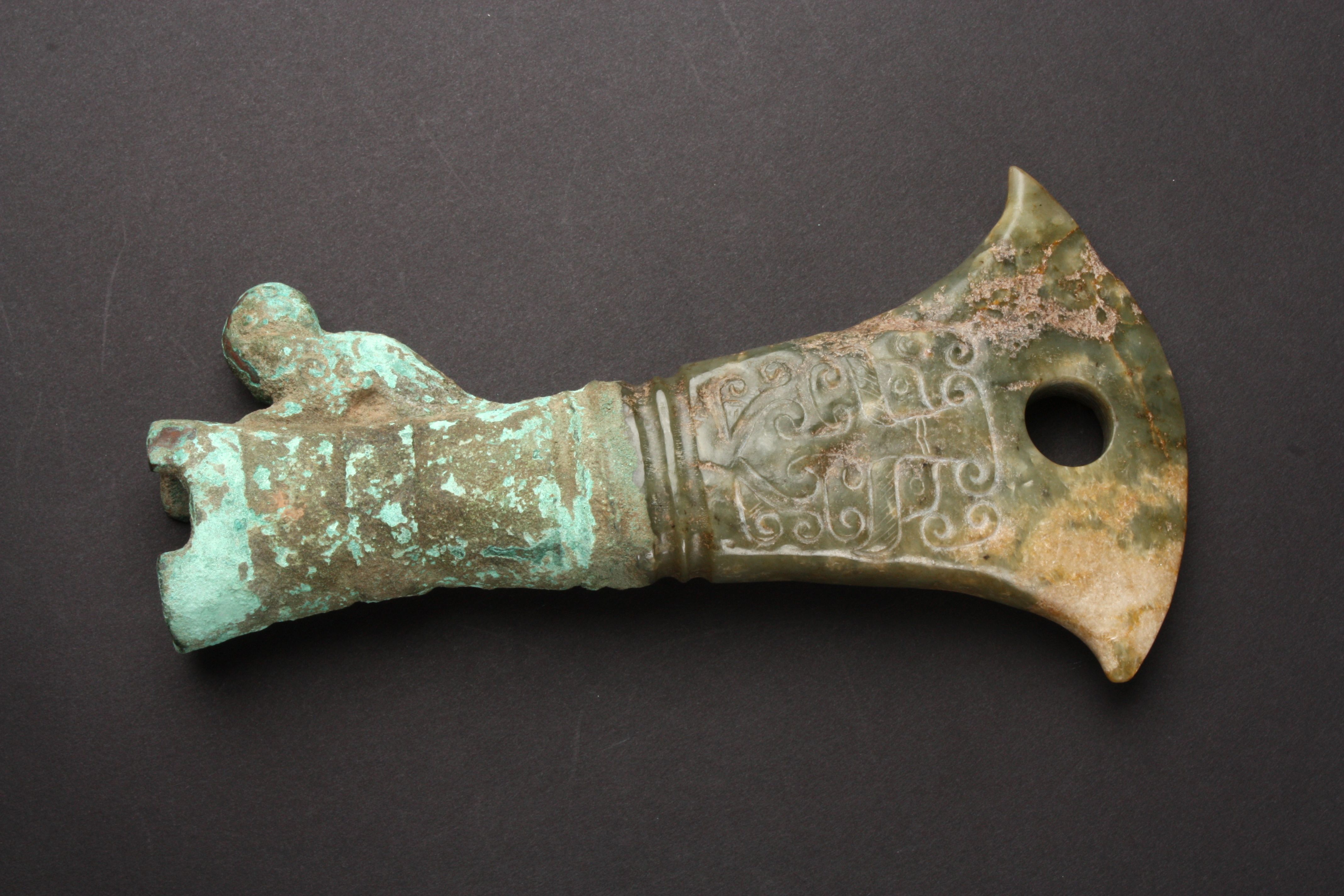 A carved jade axe head in archaic style the jade carved in low relief ...