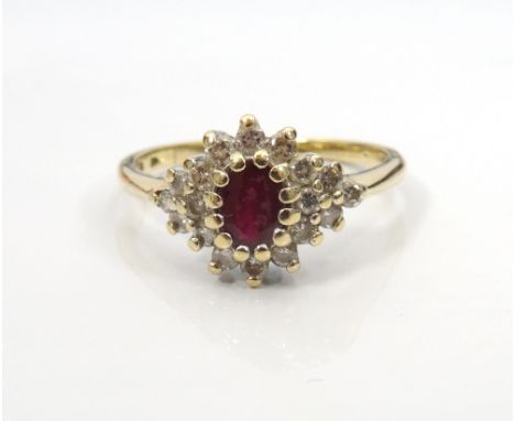 RUBY AND DIAMOND CLUSTER RINGthe central oval cut ruby in twelve diamond surround and with further diamonds to the shoulders,