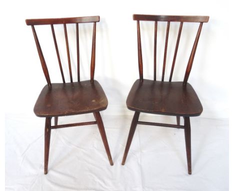 PAIR OF ERCOL DINING CHAIRSwith shaped top rails above stick backs and elm seats, standing on turned tapering supports