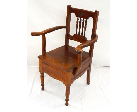 'HITCHINGS LTD.' EDWARDIAN MAHOGANY COMMODE CHAIRwith a spindle back and outswept arms above a lift-up lid with recess for ch