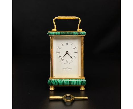 A brass and malachite mounted carriage clock by The London Goldsmiths Company, Pall Mall, having a shaped swing handle over a