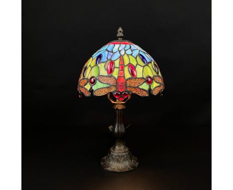 A Tiffany style Dragonfly lamp with a leaded glass shade in colours on a cast Art Nouveau style brass baluster form stem. H.3