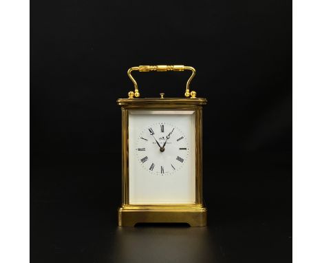 A Matthew Norman brass carriage clock having a swing handle above a moulded cornice, the enamelled dial bearing Roman numeral