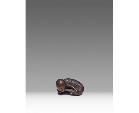 A JAPANESE WOOD NETSUKE OF A MERMAID (NINGYO) EDO PERIOD, 19TH CENTURY Probably Nagoya, the smiling siren finely carved in re