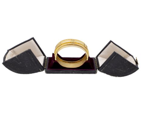 A mid 19th century gold bangle, the front with applied strap detail, between reeded and granulated borders, with ropetwist de