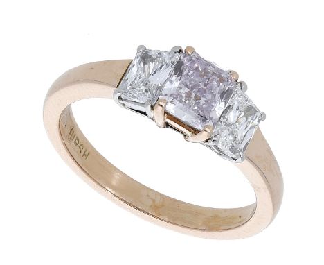 A coloured diamond ring by Hirsch, the central diamond of pink tint, weighing 0.70 carat, between two trapezoid-cut diamonds,