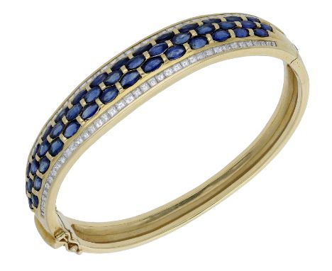 A sapphire and diamond bangle, the hinged bangle set to the front with marquise-cut sapphires and step-cut diamonds, stamped 