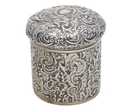 A Victoria silver cylindrical box and cover, repoussé decorated throughout with arabesque scrolls and foliage, parcel gilt in