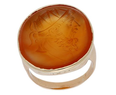 An antique carnelian intaglio ring, carved to depict the profile of a deity, possibly the sun god Sol, with ‘radiate’ crown, 