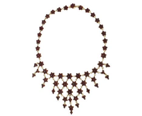 A late 19th century ‘Bohemian garnet’ bib necklace, designed as a series of flowerhead clusters set with rose-cut red stones,