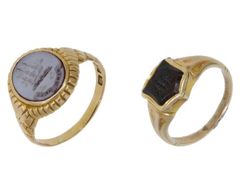 Two antique hardstone signet rings, the first inset with an oval banded agate plaque and engraved with a sailing ship crest a