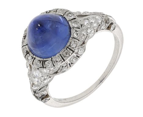 An early 20th century sugarloaf sapphire and diamond ring, the sugarloaf sapphire cabochon within a finely pierced surround o