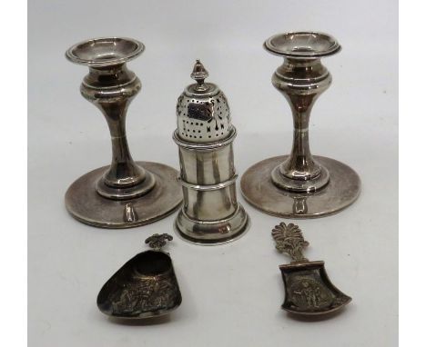 Pair of weighted silver candlesticks Birmingham indistinct year mark ,&nbsp; Silver sugar sifter with an armorial crest Birmi