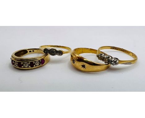 Four gold rings: Two 1920s to 1930s three stone diamond rings in 18ct gold and platinum, both size J. A gypsy set three stone